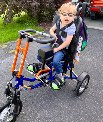 Karter Goodchild Poses For a Picture on His Adaptive Bicycle