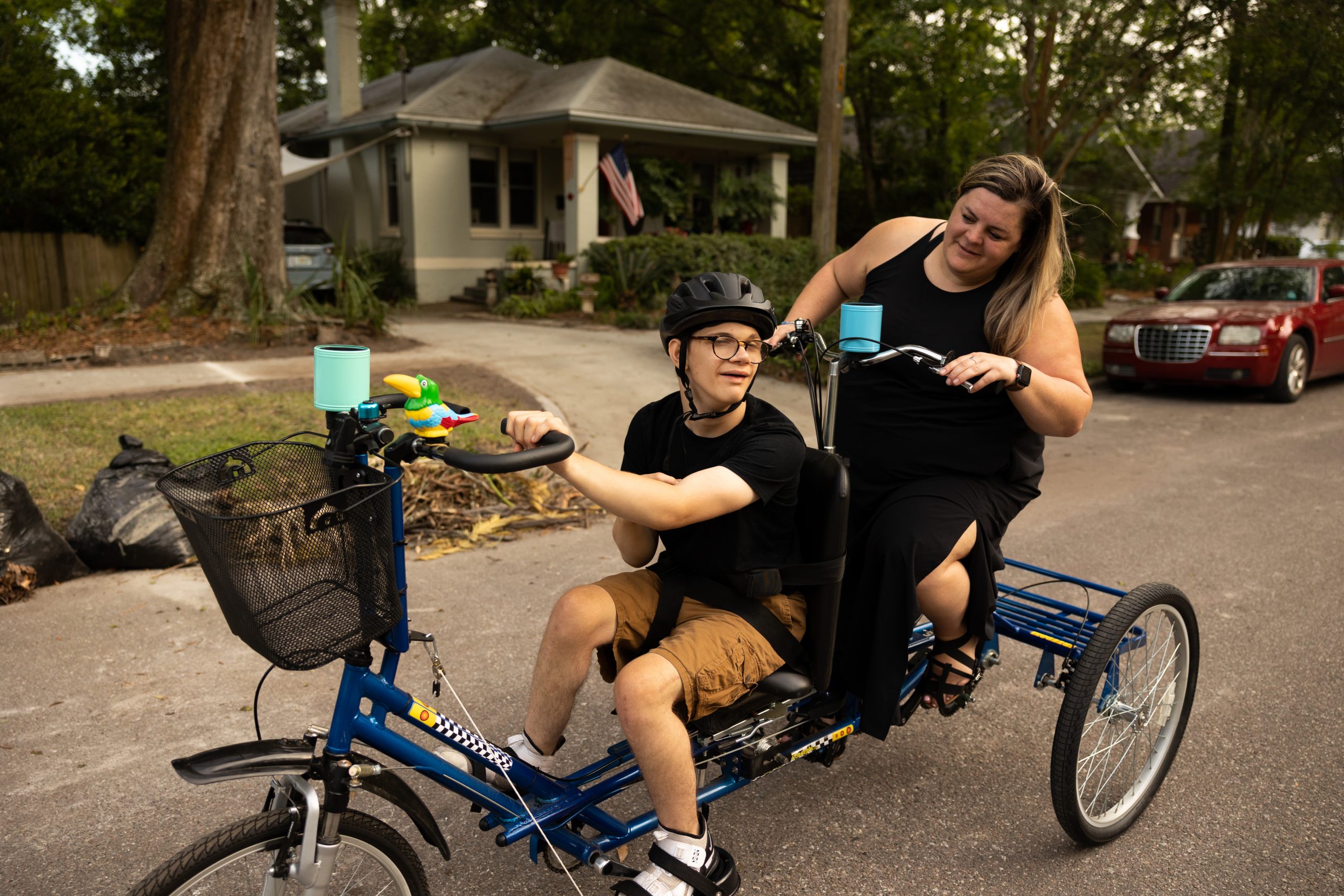 Tyler and Caitlin riding an adaptive tandem bike on a residential street.