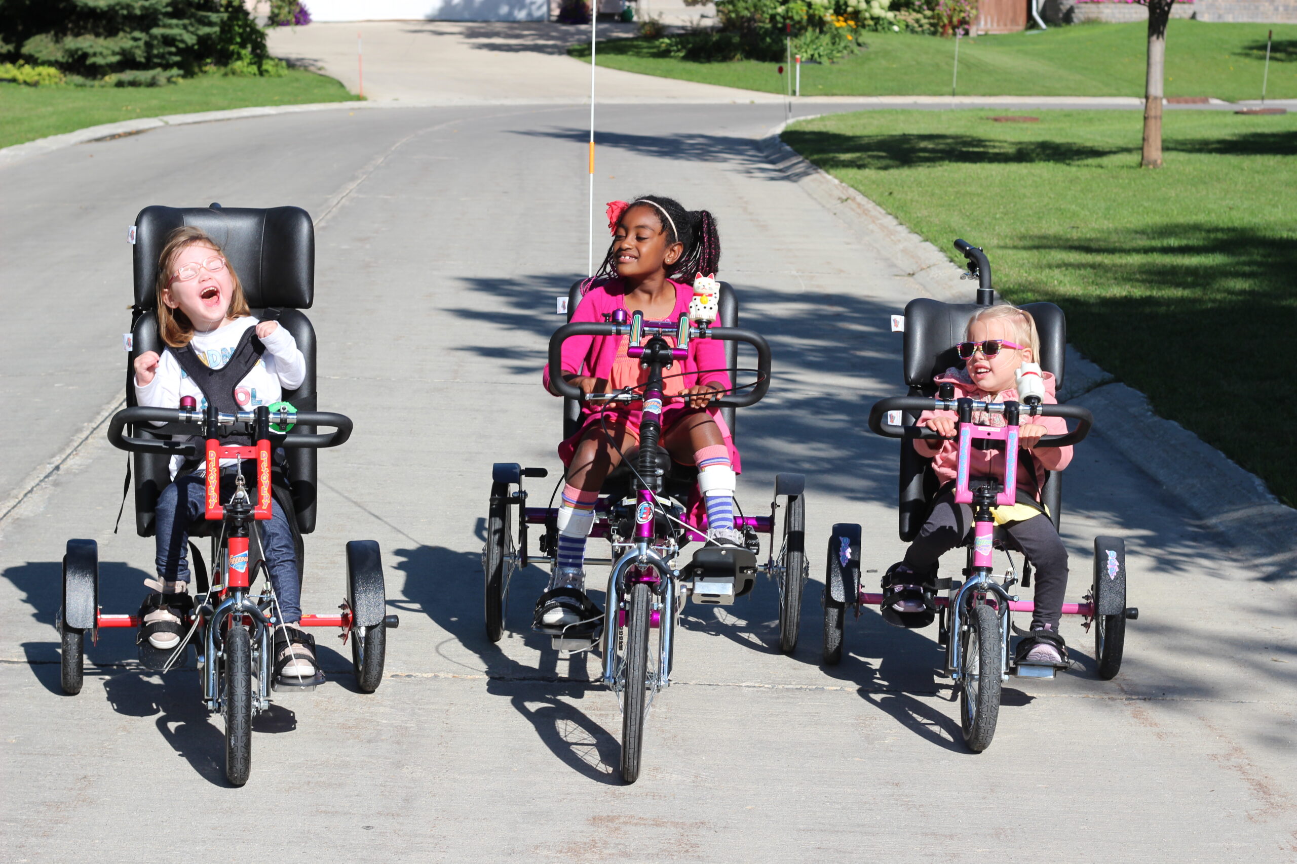 3 girls on their adaptive bikes. This photo wants you to subscribe to our newsletter